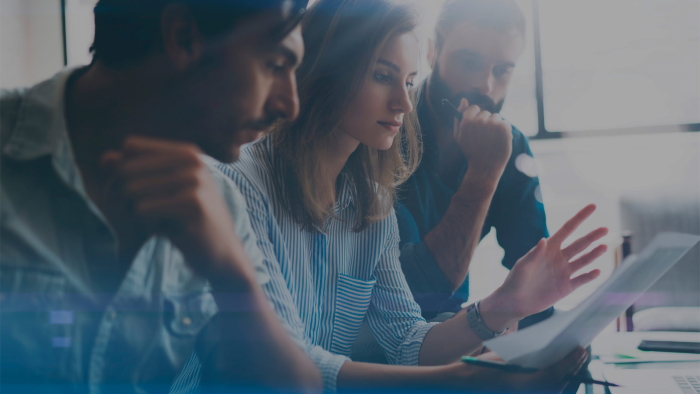 kaks meest ja naine nende keskel arutlevad keskkonnateemadel vaadates paberit enda ees