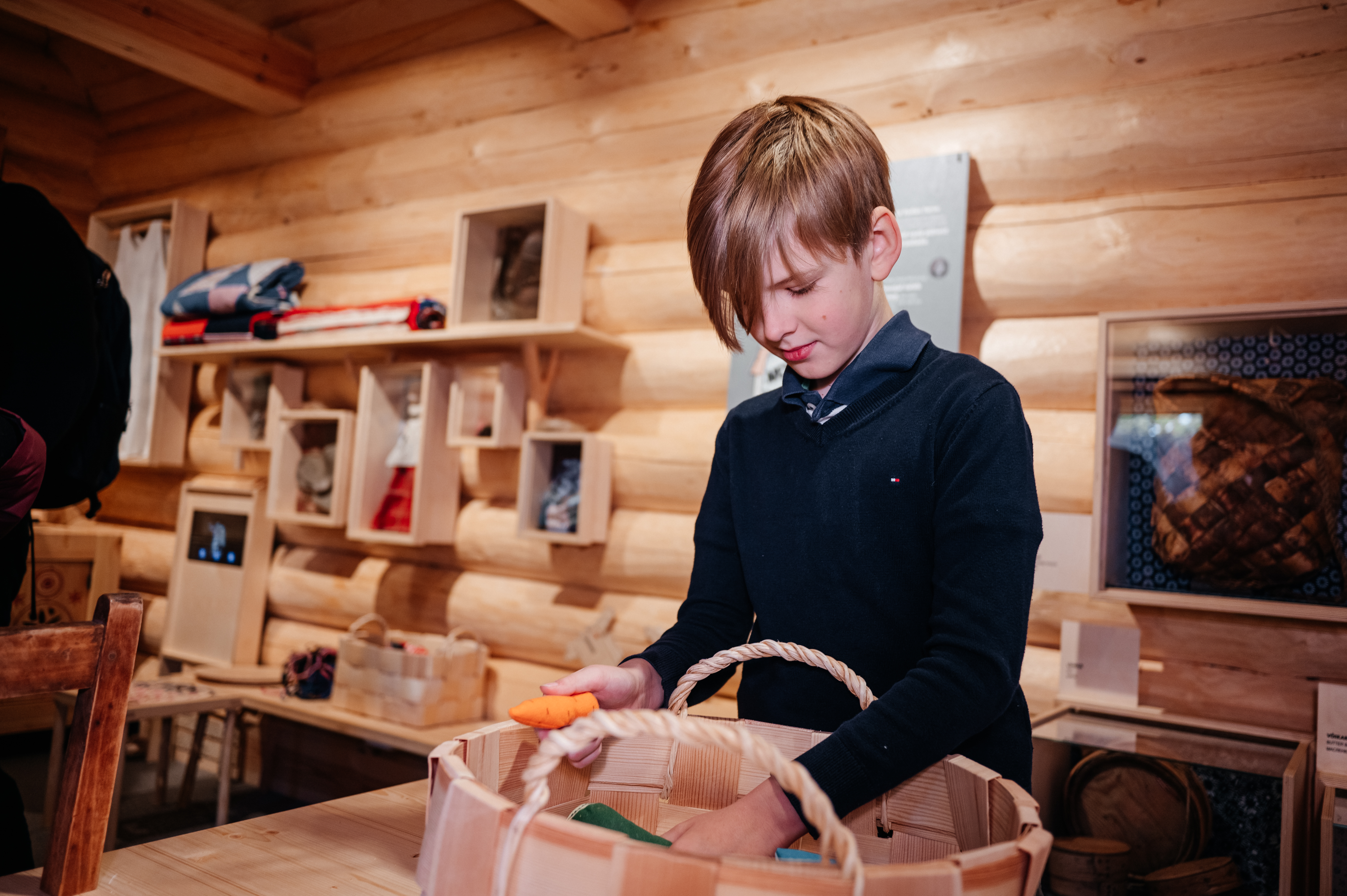 Poiss uurib Kolga talu aida-lauda raidas näitust "Iga väike samm loeb".