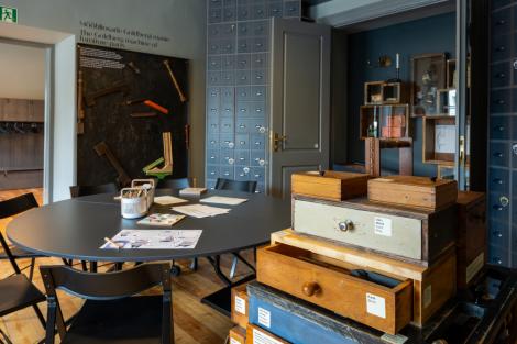 Toas esiplaanil erinevat puidu värvi ja sinistes toonides ning erinevate suurustega sahtlid 